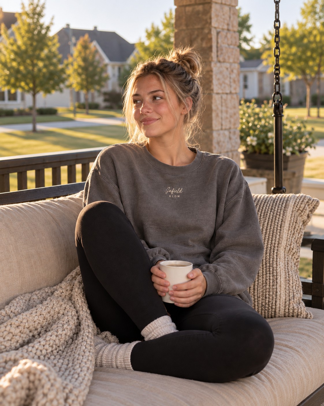 a girl curled up on a porch swing with a mug, morning light coming through the railing